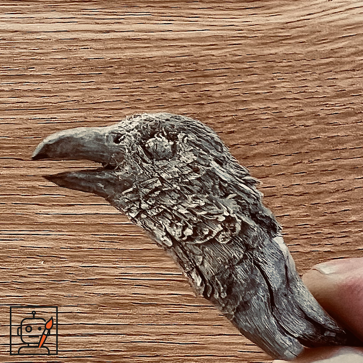A wood carving of a crow made from a piece of mulch.