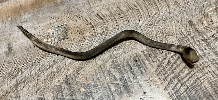 Post torch burned view of the hard-carved wooden rattlesnake rattle.